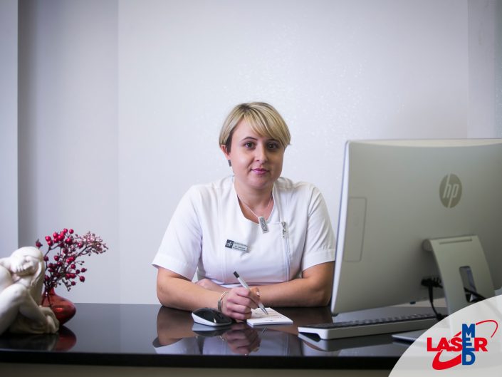 Amelia Langer-Łukasik specjalistka laseroterapii siedząca w gabinecie przed komputerem